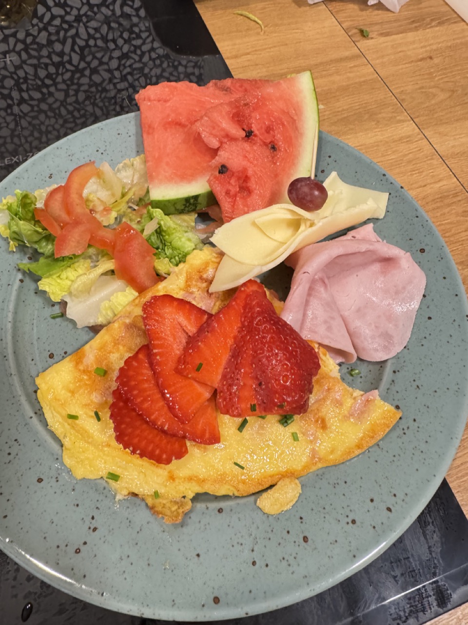 Serviertes Frühstück mit Omelett, Obst und Käse